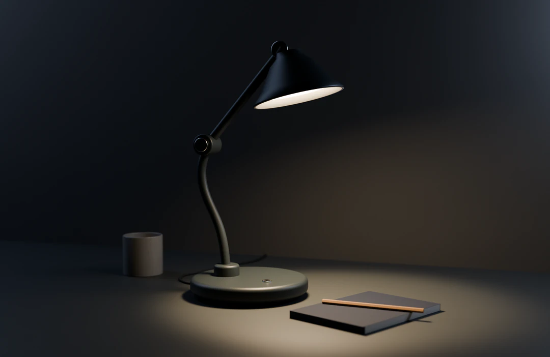 Arc 01 in ink on a dark desk at night, its shade throwing a warm pool of light across a closed notebook and pencil.